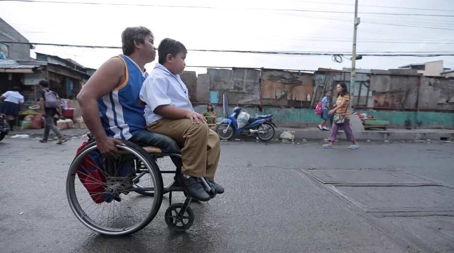 Wheelchair-bound father takes son to school in his wheelchair every day, rain or shine, earns praises and sympathy from netizens