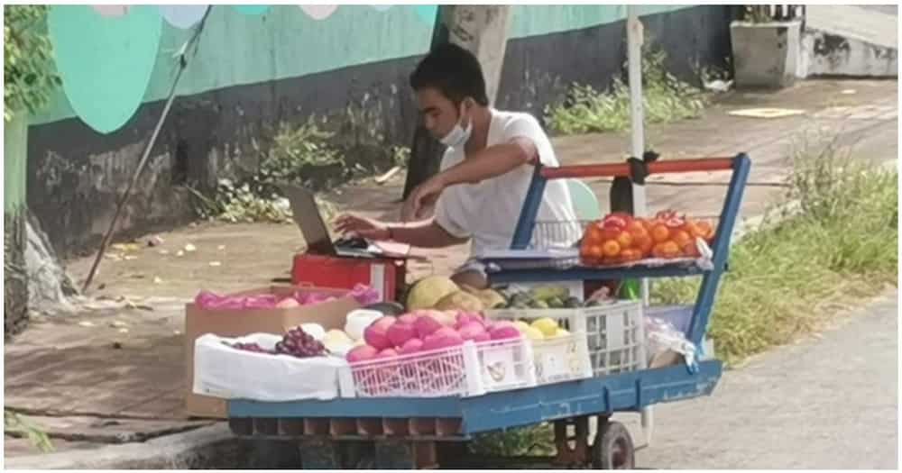 Fruit vendor na naka-laptop habang naglalako, dumadalo pala ng kanyang online classes