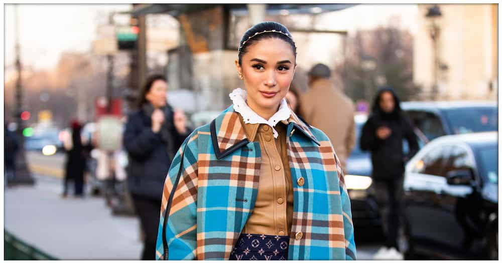 Heart Evangelista, wearing a tan leather long shirt, Louis Vuitton mini skirt, blue and beige checked coat, beige boots and printed bag, during Paris Fashion Week